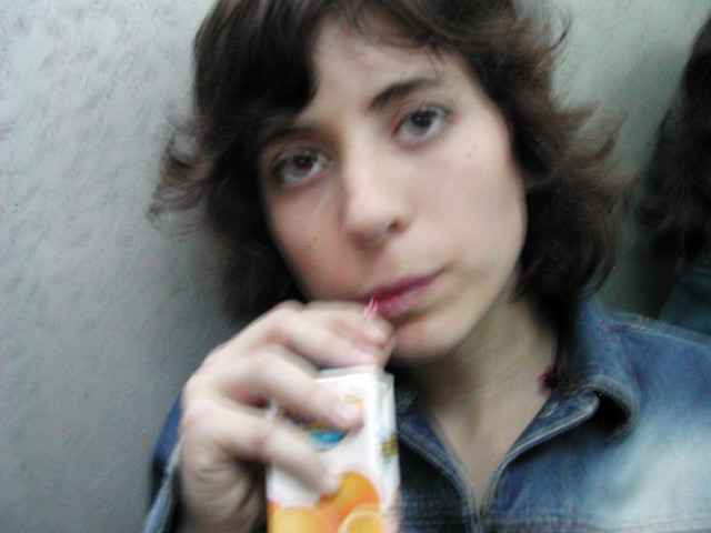 Mujer tomando un vaso de zumo de naranja.